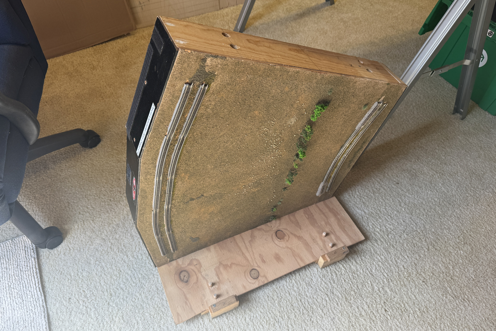 Z scale module on the floor with part of the tranportation clamp showing. Another module will be placed on the clamp.